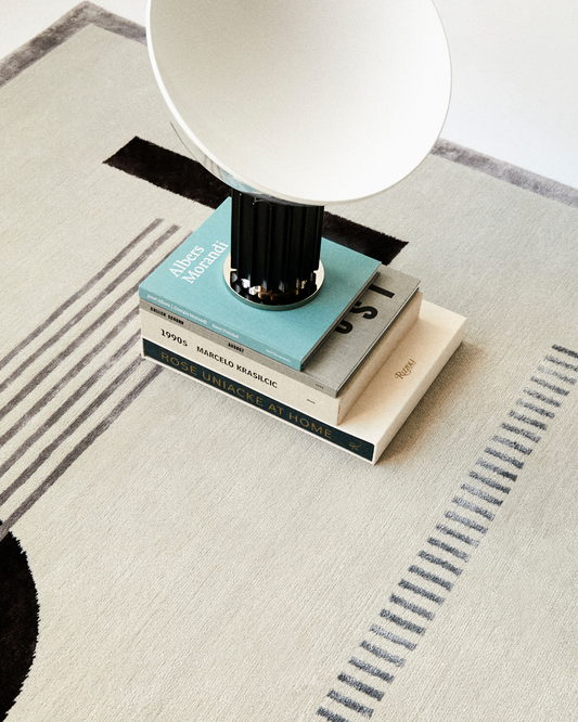 Close-up of the Jean rug's intricate hand-knotted craftsmanship, highlighting the smooth texture of bamboo silk and wool fibers in soft blue and cream.