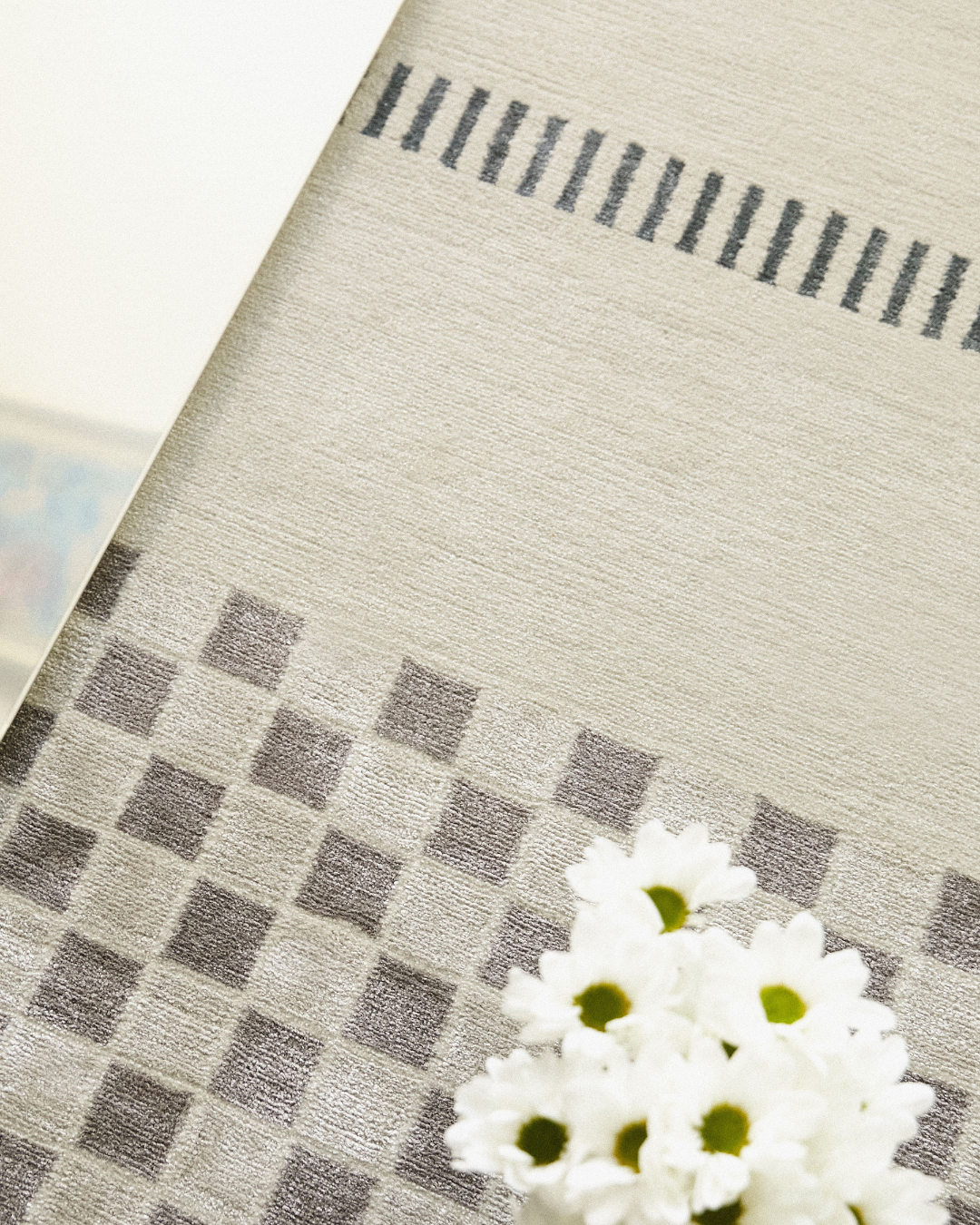 Detailed shot of the Jean rug's geometric pattern, showing the sharp lines and meticulous hand-knotted design in contrasting blue and cream.