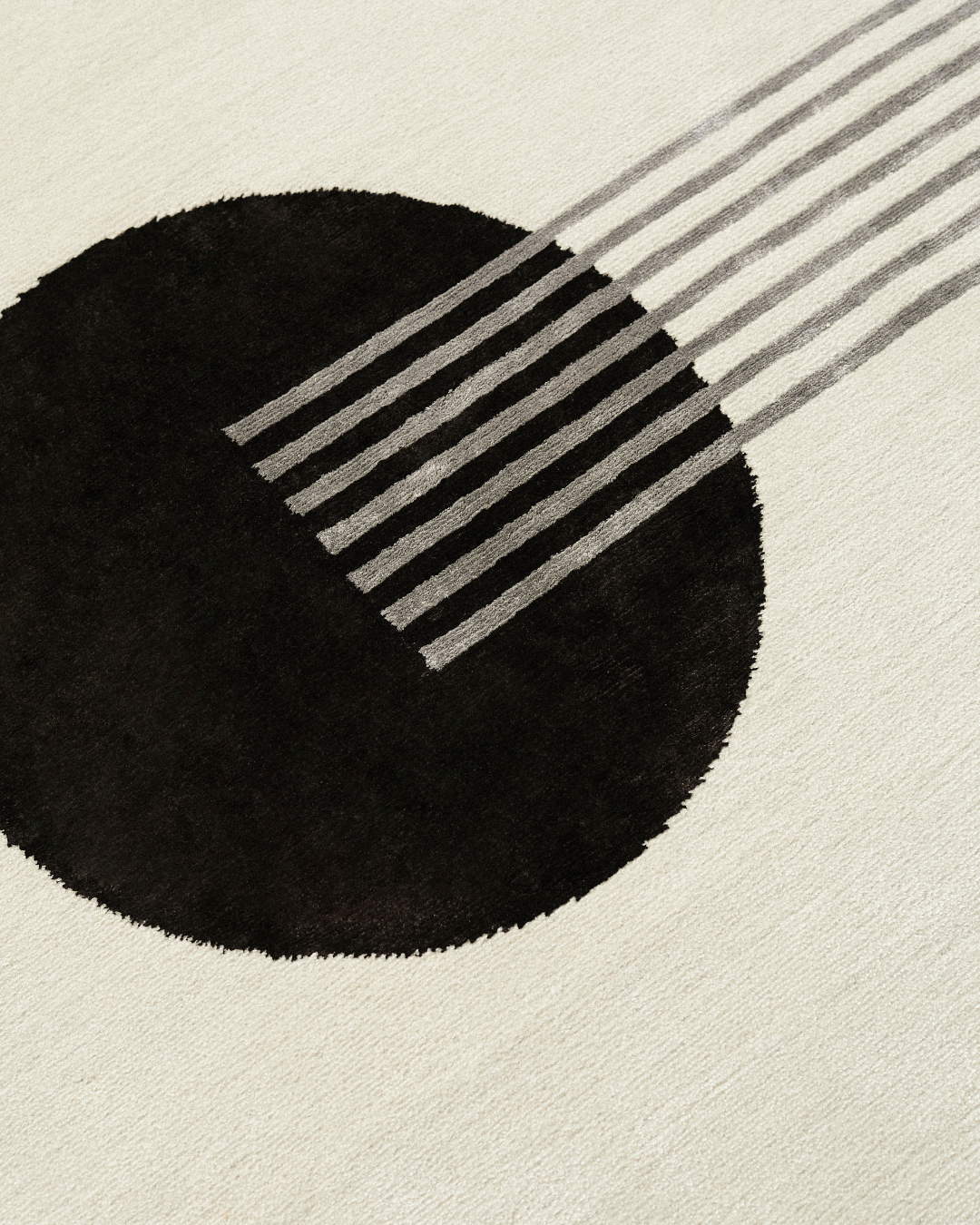 Detailed shot of the Jean rug's geometric pattern, showing the sharp lines and large chocolate circle. The meticulous hand-knotted design is crafted from wool and bamboo silk.
