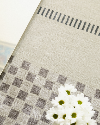 Detailed shot of the Jean rug's geometric pattern, showing the sharp lines and meticulous hand-knotted design in contrasting blue and cream.