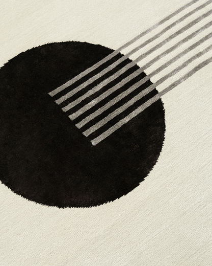 Detailed shot of the Jean rug's geometric pattern, showing the sharp lines and large chocolate circle. The meticulous hand-knotted design is crafted from wool and bamboo silk. 