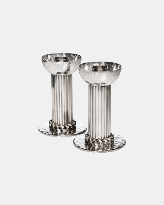 Silver-plated candlesticks by Jean Desprès. Fluted shafts, hammered bases and receptacles, curb chain collar.
